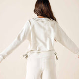 Person wearing a white outfit with a neutral background