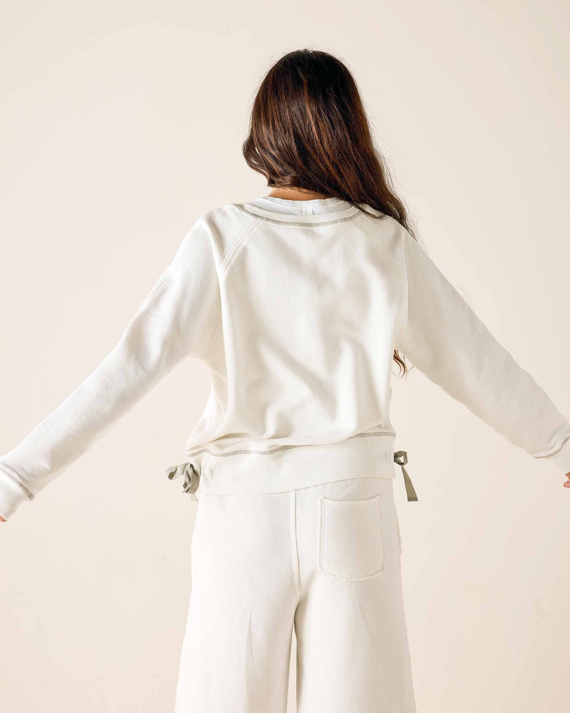 Person wearing a white outfit with a neutral background
