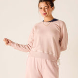 Woman wearing a pink outfit against a plain background