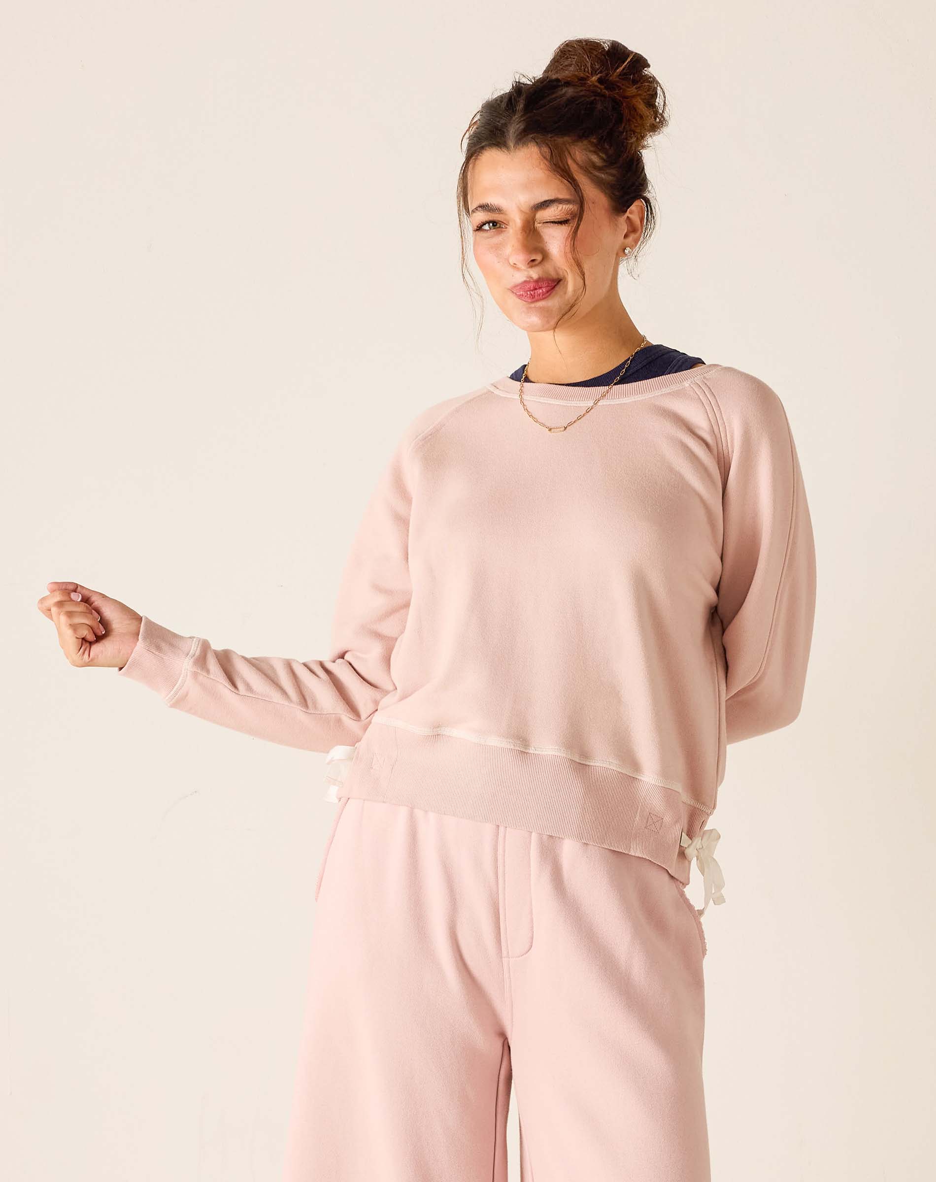 Woman wearing a pink outfit against a plain background
