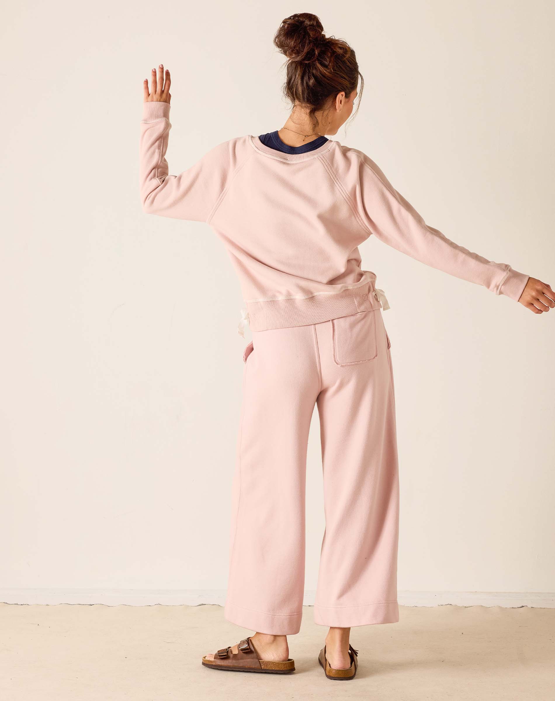 Woman wearing a pink outfit with a neutral background