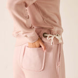 Pink outfit with a focus on pants and jacket on a light background