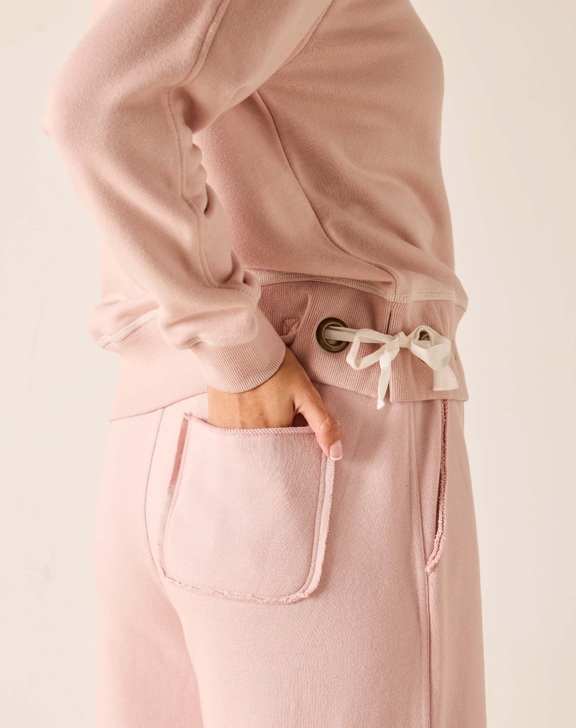 Pink outfit with a focus on pants and jacket on a light background
