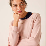 Woman wearing a pink sweater with a neutral background