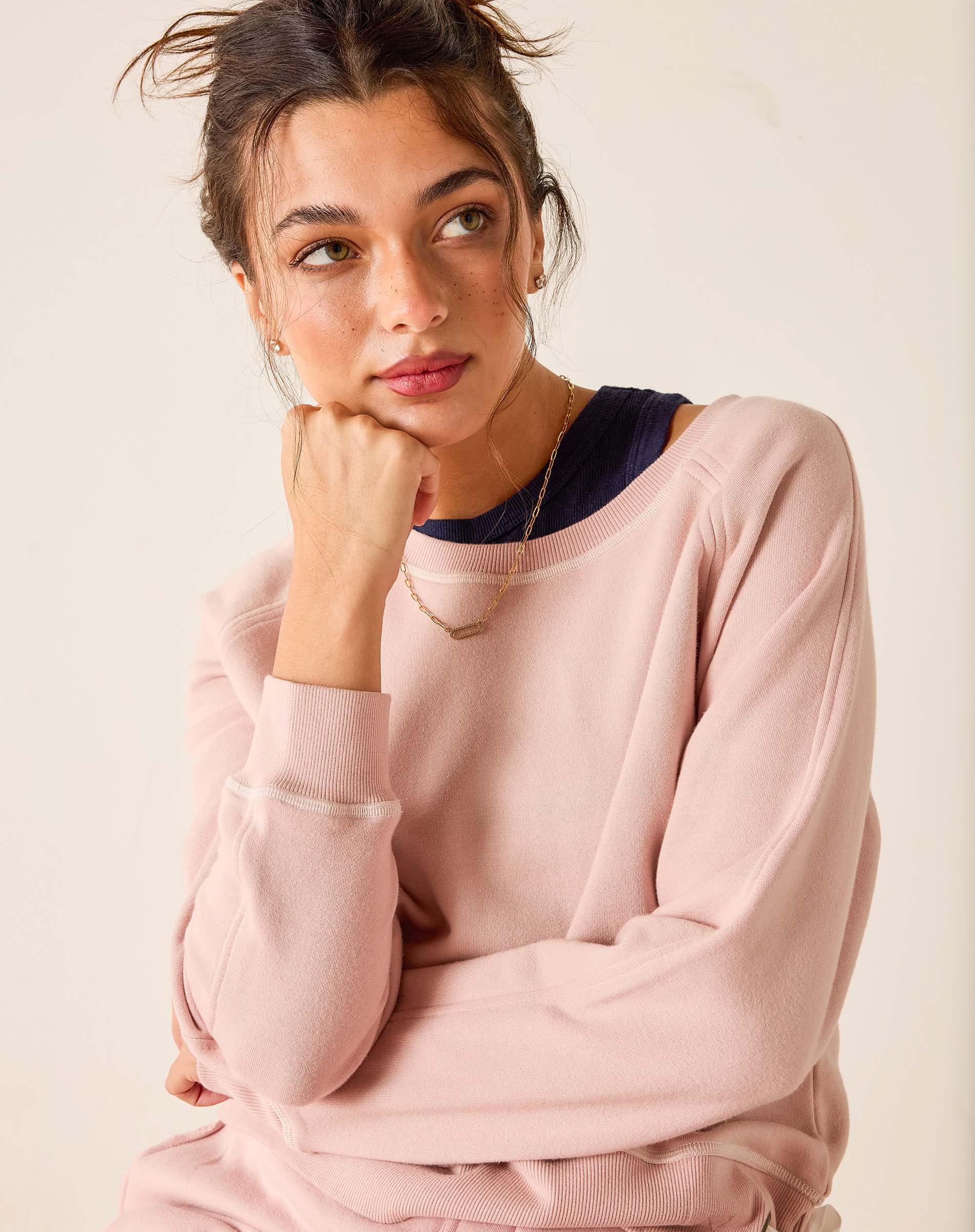 Woman wearing a pink sweater with a neutral background