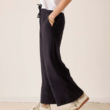 Black wide-leg trousers with a drawstring waist and relaxed fit.