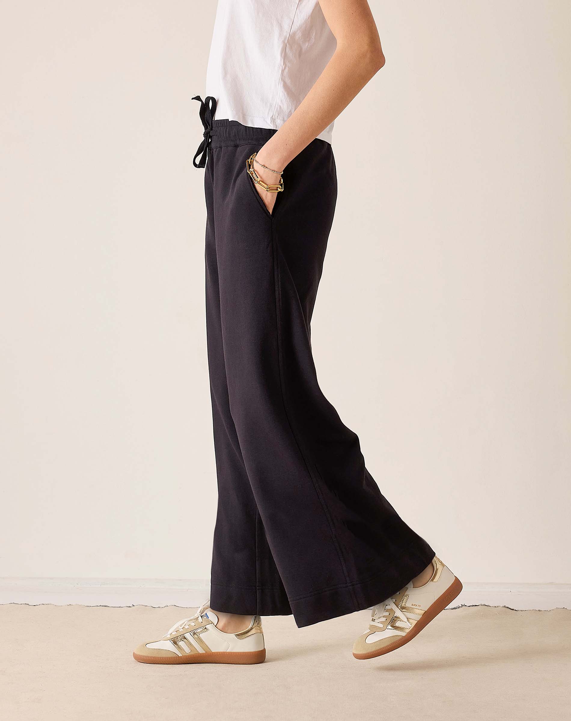 Black wide-leg trousers with a drawstring waist and relaxed fit.