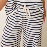 Nautical striped outfit with a top and wide-leg pants on a neutral background
