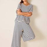 Woman wearing a black and white striped outfit against a plain background