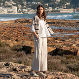 MERSEA women's travel-friendly bone wide-leg pants paired with a striped knit top in a coastal setting.