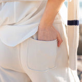 Bone wide-leg pants with a large front pocket and soft knit texture.