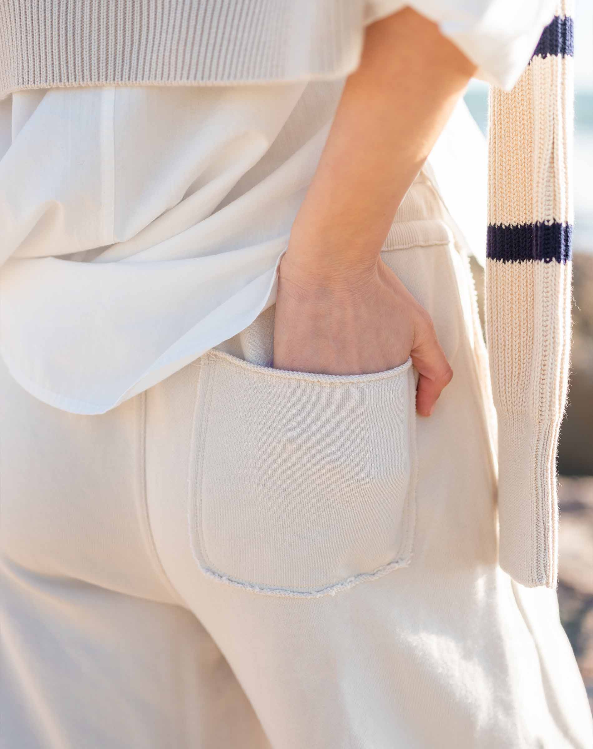 Bone wide-leg pants with a large front pocket and soft knit texture.