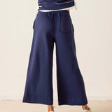 Navy blue wide-leg pants worn by a person on a plain background