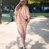 Woman in a pink outfit walking outdoors on a sunny day