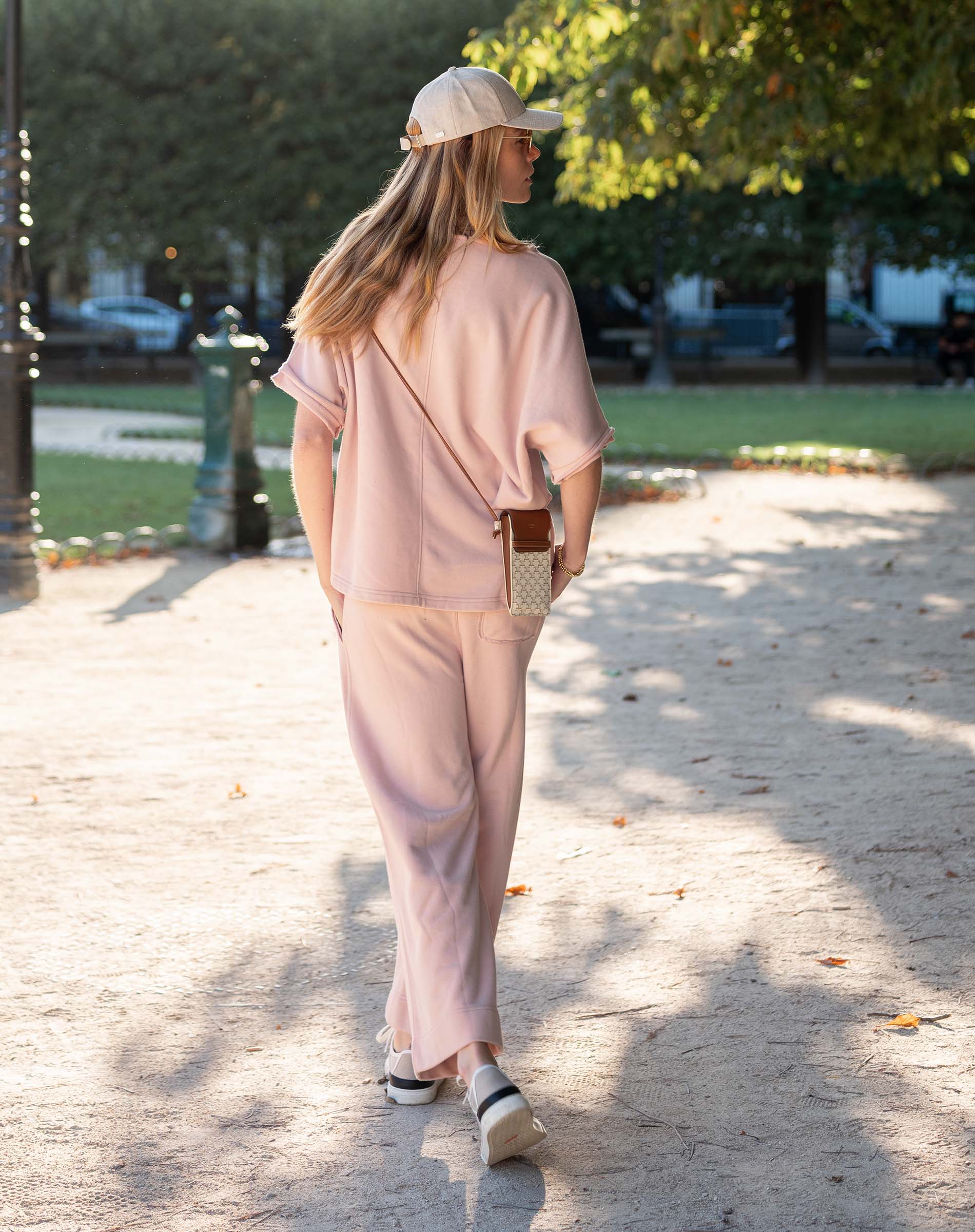 Woman in a pink outfit walking outdoors on a sunny day