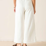 Person wearing white wide-leg pants on a plain background