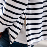 Close-up of a person wearing a black and white striped shirt with a zipper.
