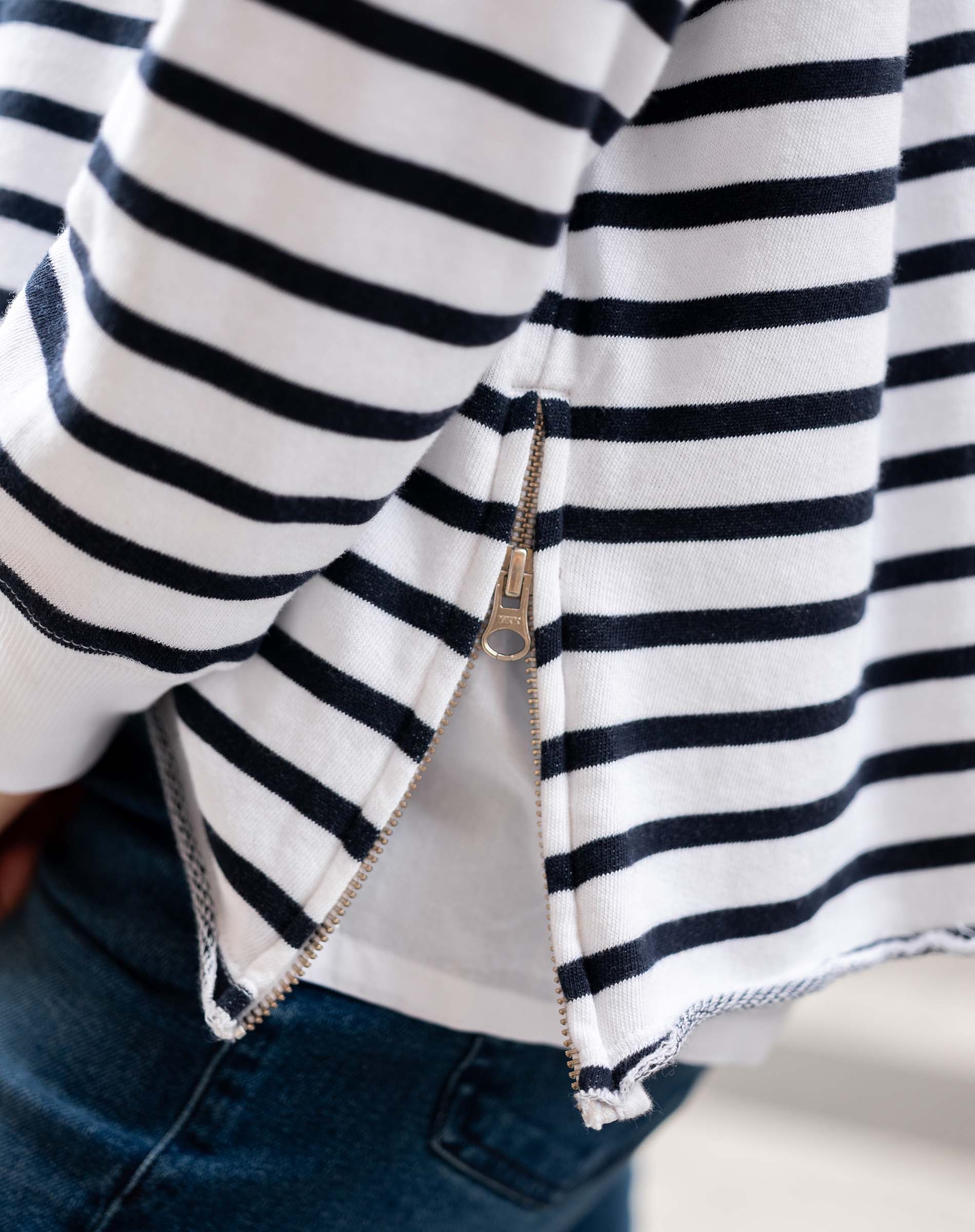 Close-up of a person wearing a black and white striped shirt with a zipper.