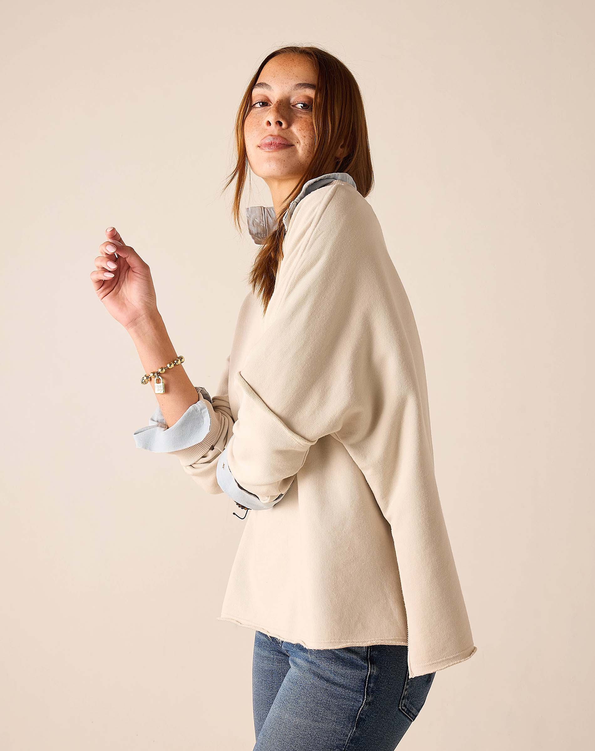 Bone crewneck knit top with folded cuffs and a light blue interior accent.