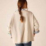 Back view of the bone crewneck knit top with long sleeves and a relaxed fit.