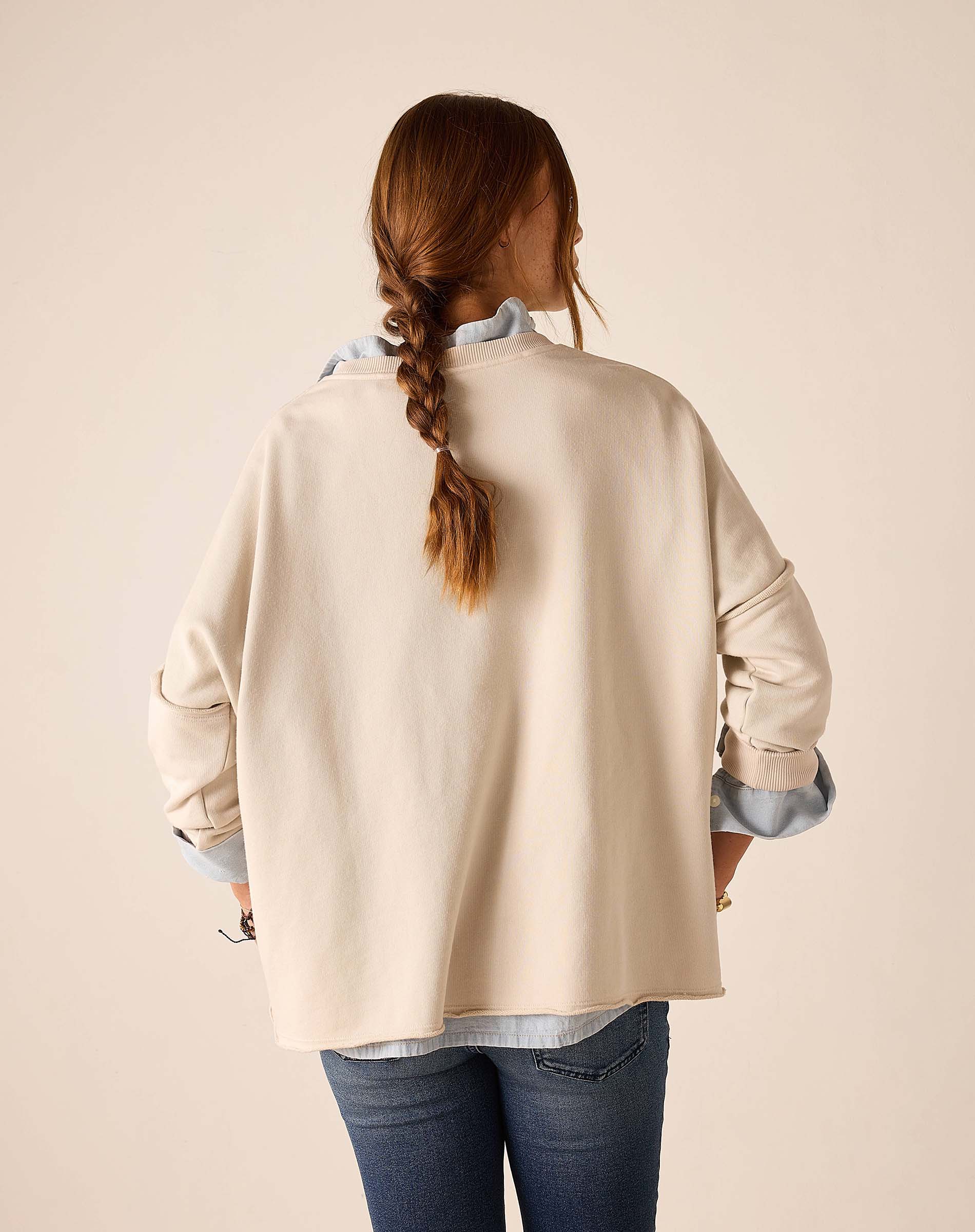 Back view of the bone crewneck knit top with long sleeves and a relaxed fit.