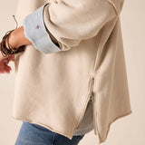 Bone-colored crewneck knit top with long sleeves and a zipper detail.