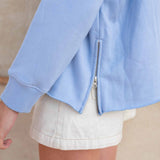 Light blue jacket with a zipper on a neutral background