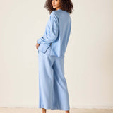 Woman wearing a light blue outfit against a plain background