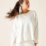 Woman wearing a white sweatshirt against a plain background