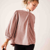 Ladies' travel-ready blush pink oversized puff sleeve cotton-blend blouse with a white ruffled collar.