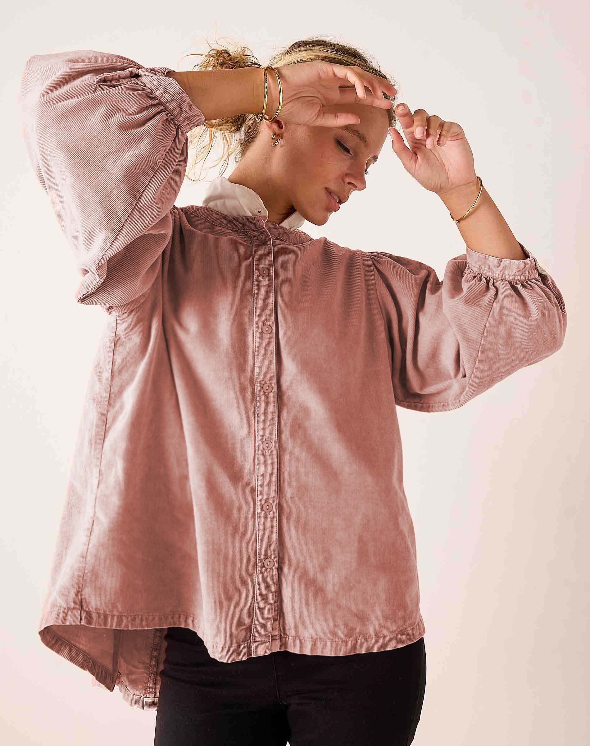 Blush pink button-down blouse with voluminous puff sleeves and button details.