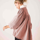 Side view of the blush pink voluminous cotton poplin shirt with gathered details and tiered construction.