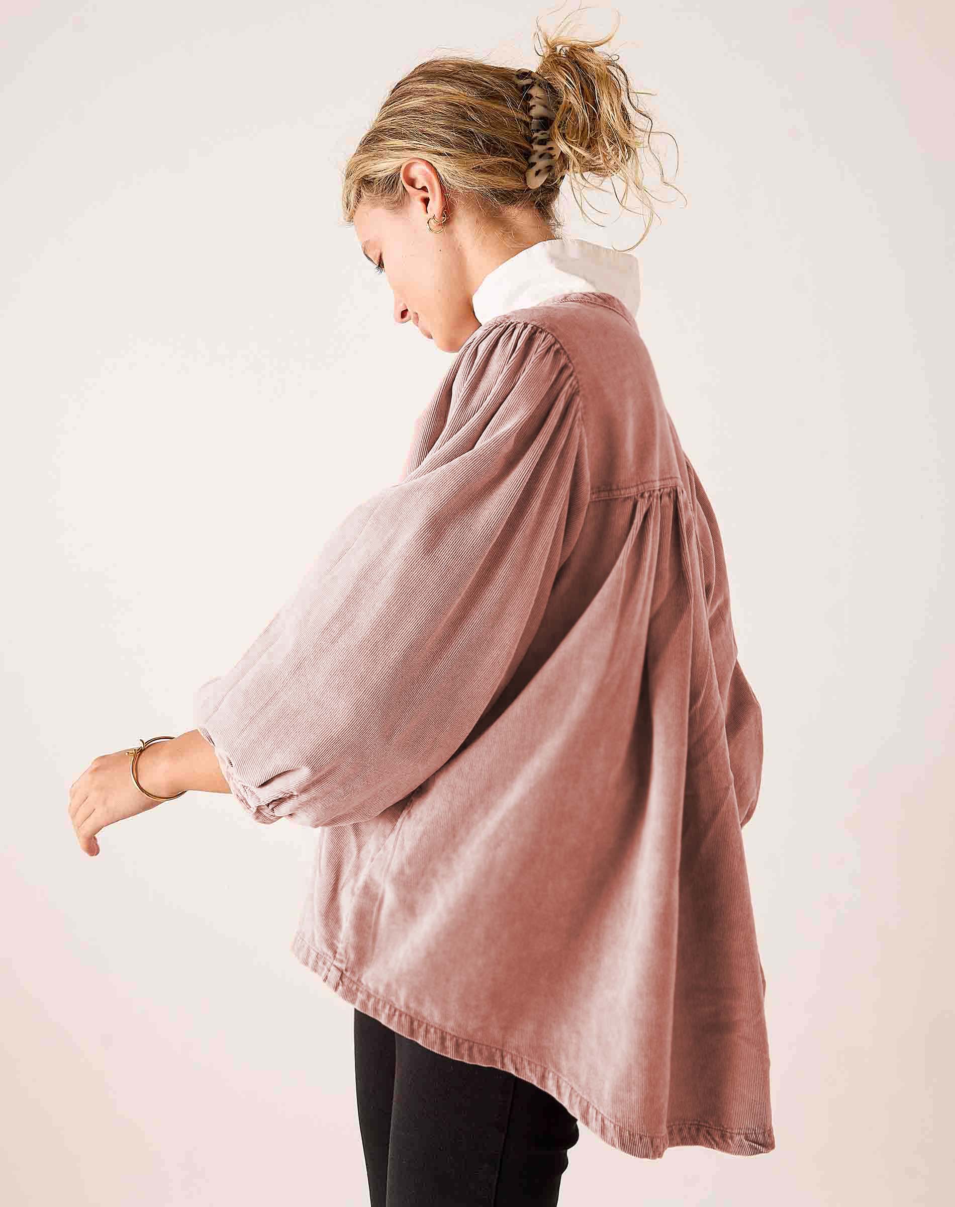 Side view of the blush pink voluminous cotton poplin shirt with gathered details and tiered construction.