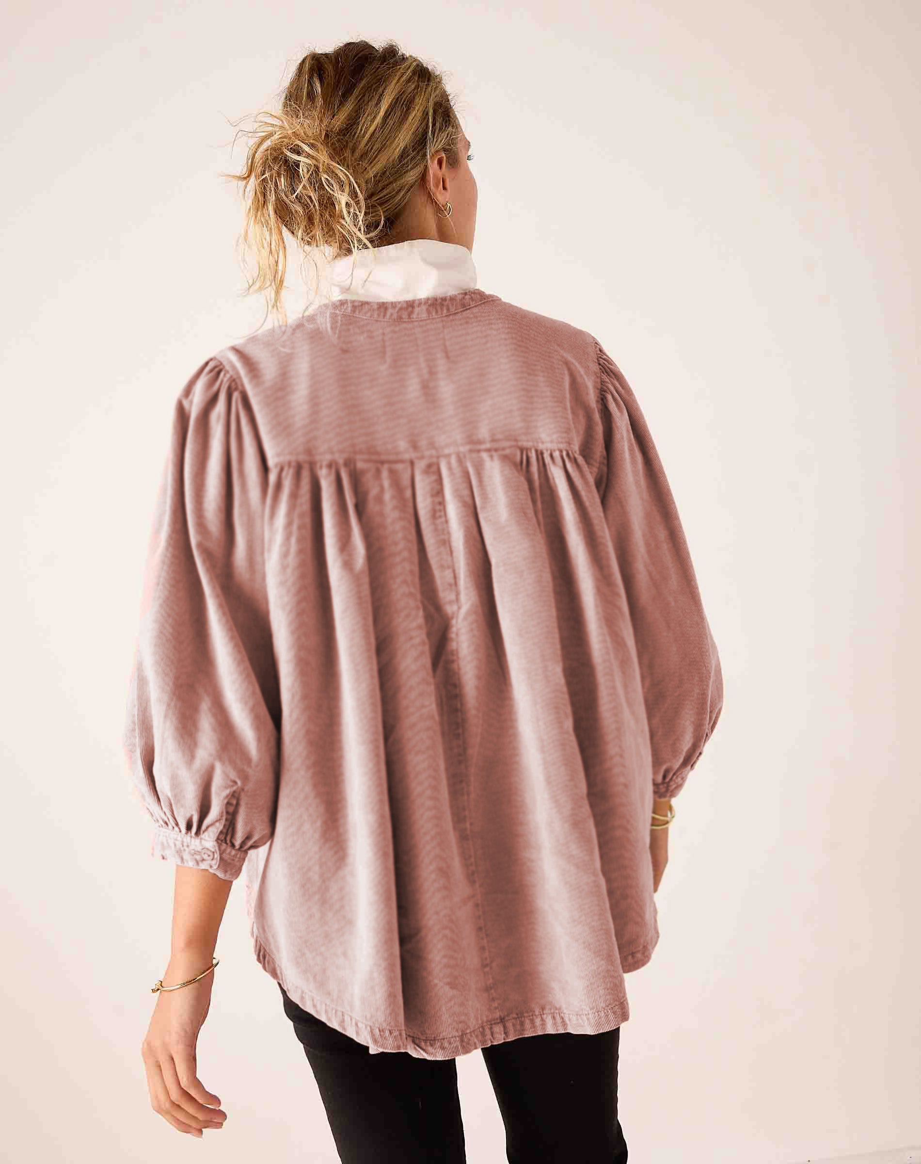Back view of women's travel-friendly blush-toned, loose-fit gathered-waist cotton-blend blouse with voluminous balloon sleeves and smocked cuffs.