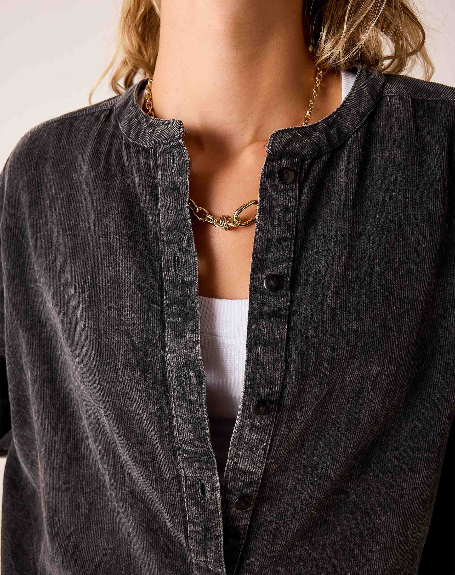 Noir button-down shirt with a ribbed knit texture and a stand collar.