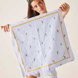 Woman holding a blue and white striped towel with bird pattern