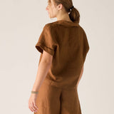 Person wearing a brown outfit against a plain background