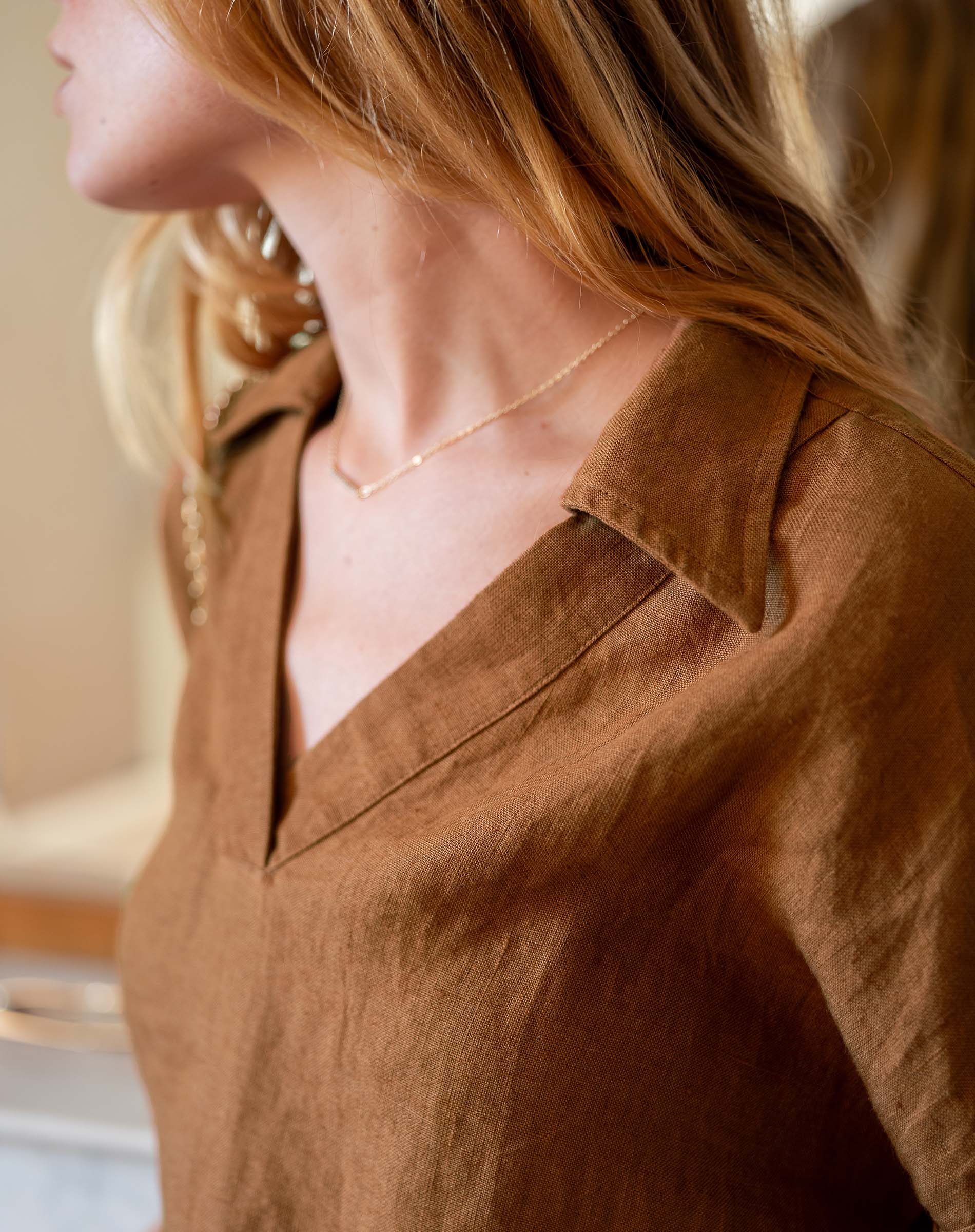 Close-up of a person wearing a brown shirt with a blurred background