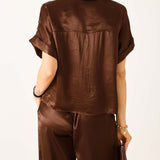 Chocolate brown boxy silk top with short sleeves and a wide neckline.