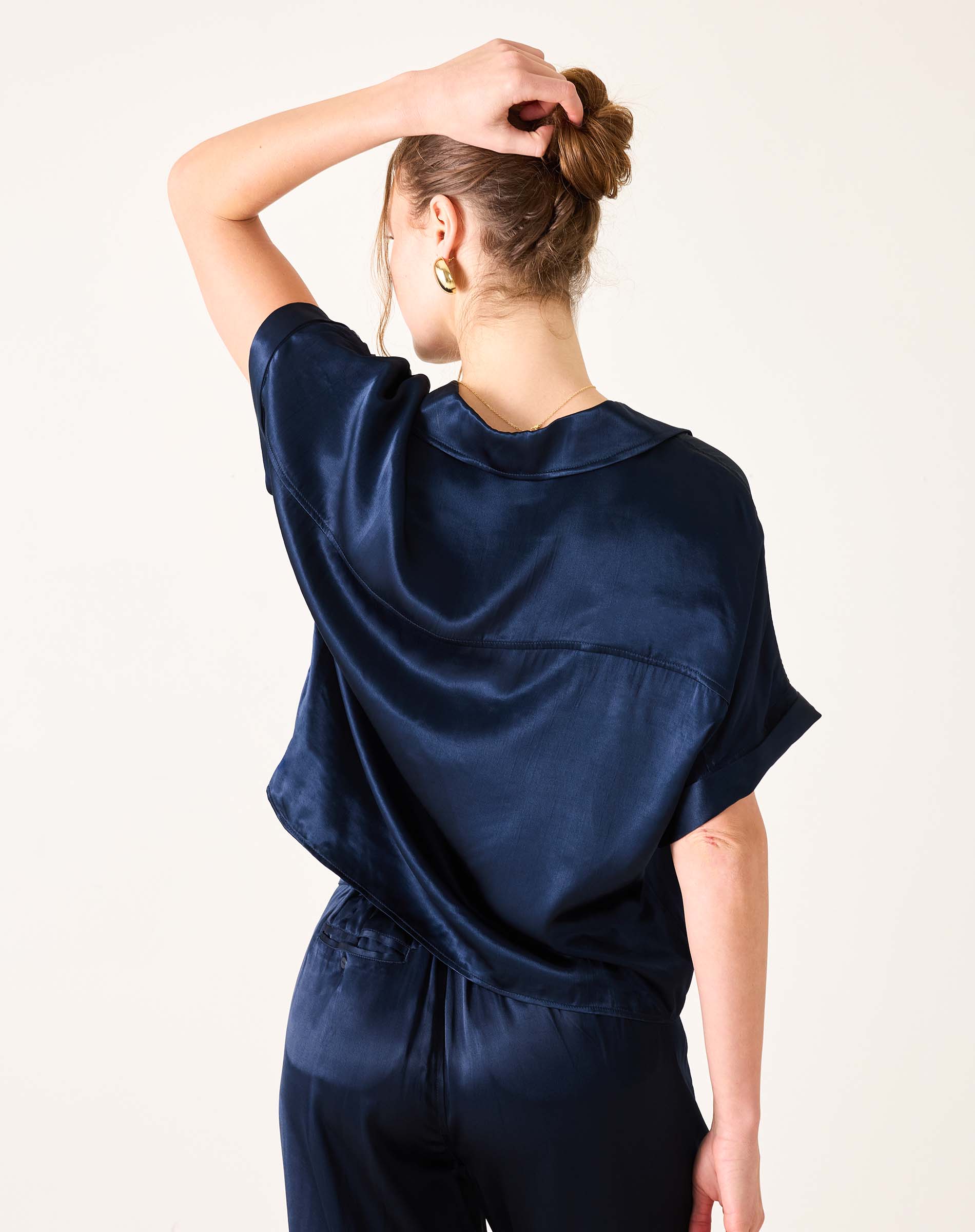 Navy blue boxy satin top with short sleeves and a soft sheen.