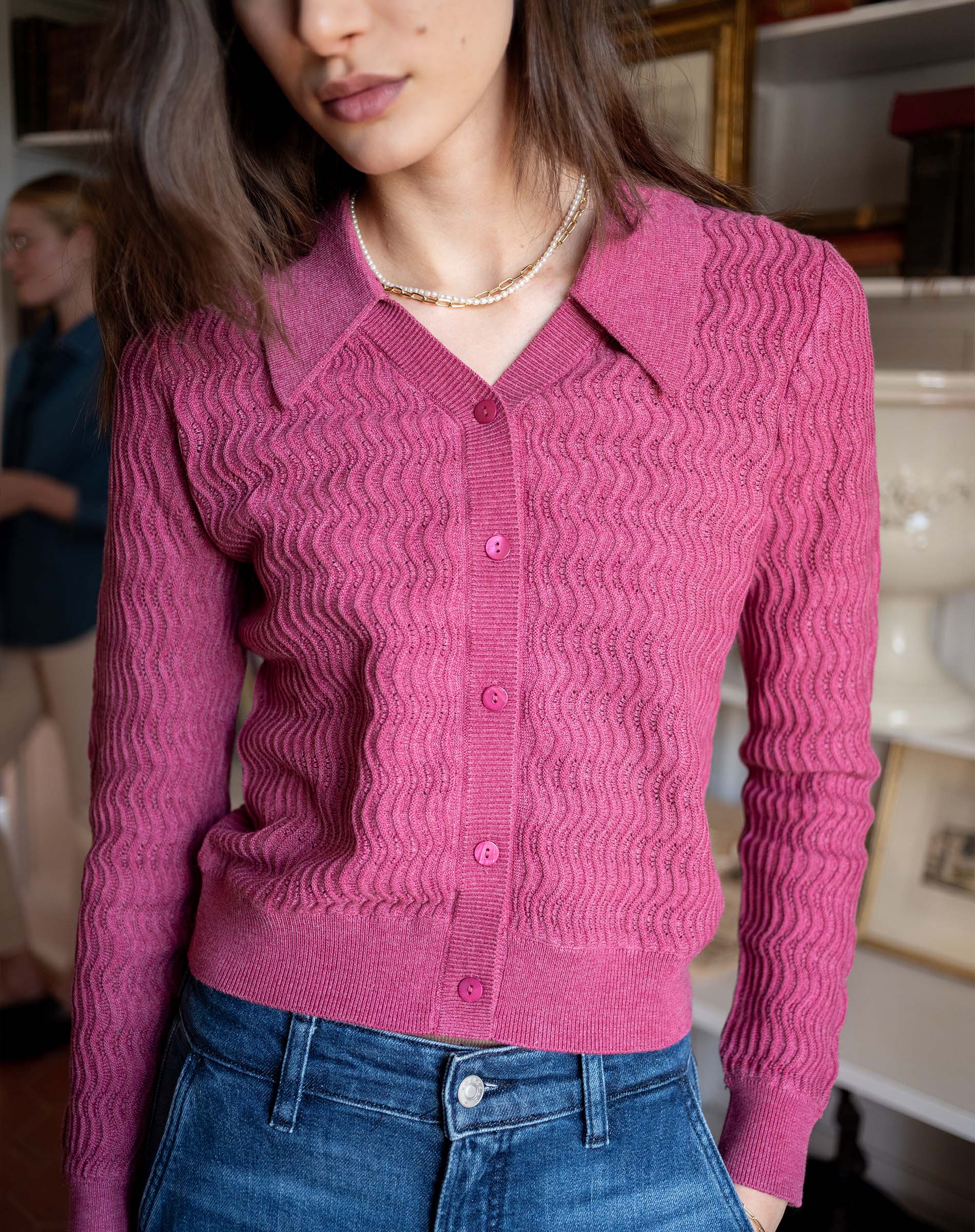 Rhubarb pink button-down knit sweater with a collar and ribbed texture.