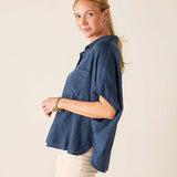 Woman wearing a blue shirt with a plain background