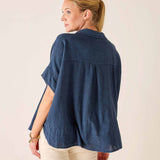 Woman wearing a blue denim shirt on a plain background