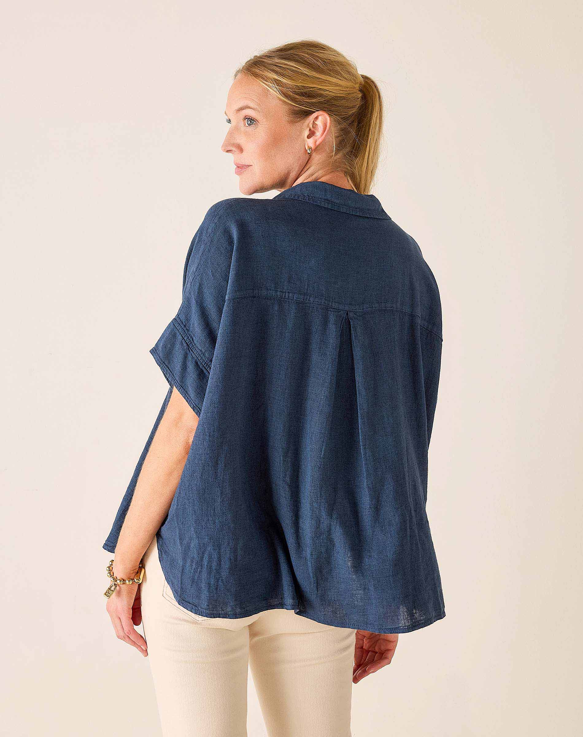 Woman wearing a blue denim shirt on a plain background