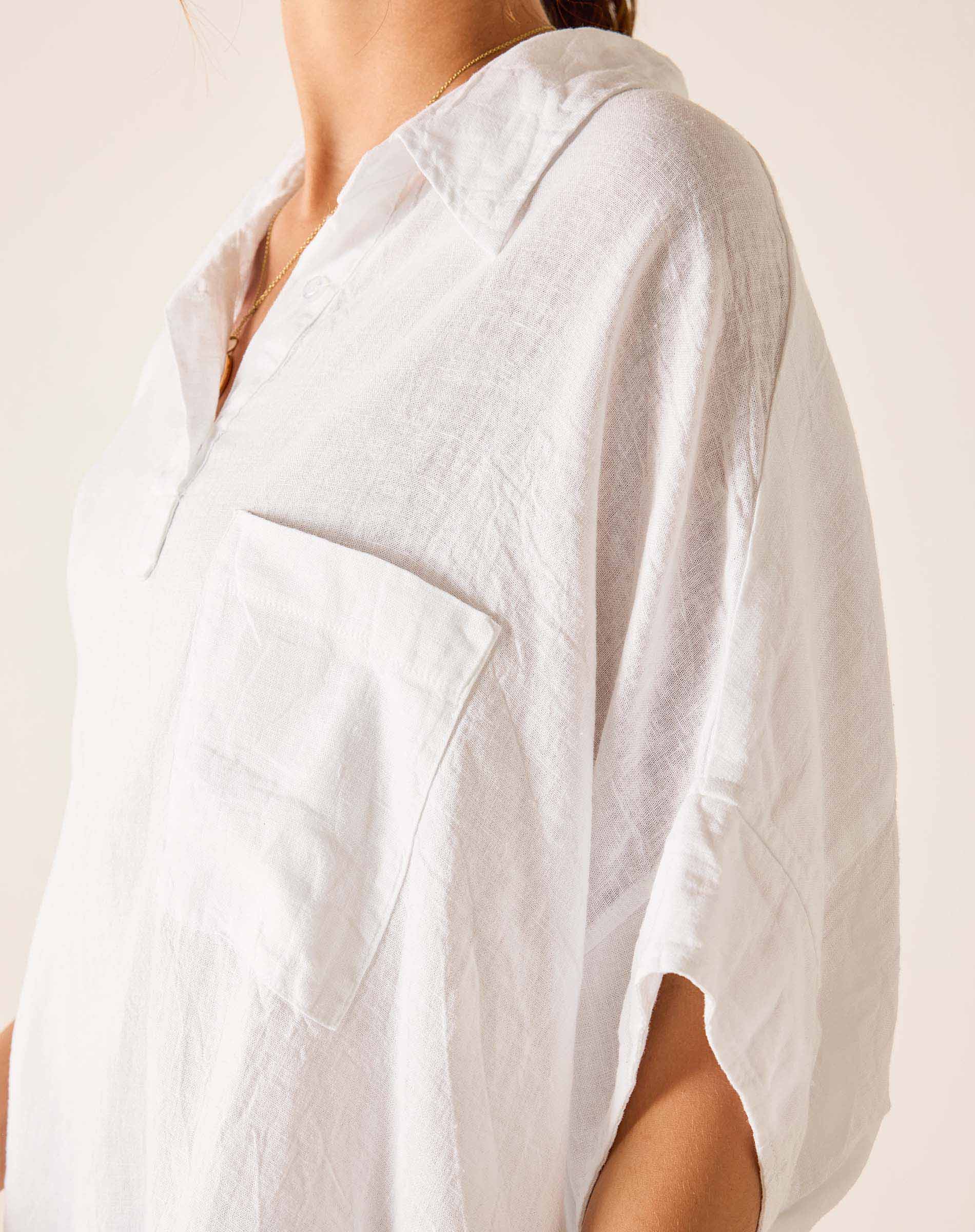 White linen shirt worn by a person on a plain background