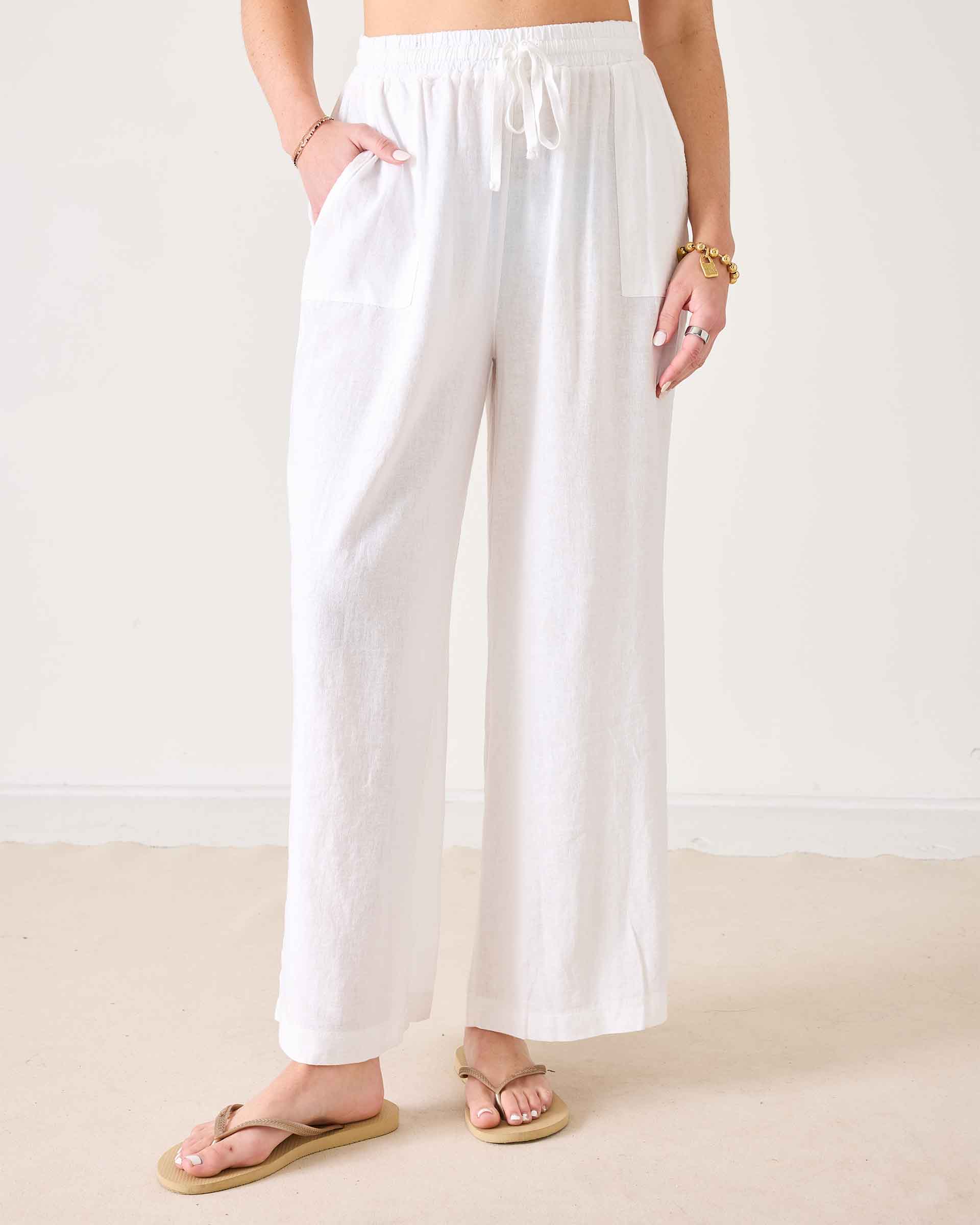 Person wearing white wide-leg pants on a plain background
