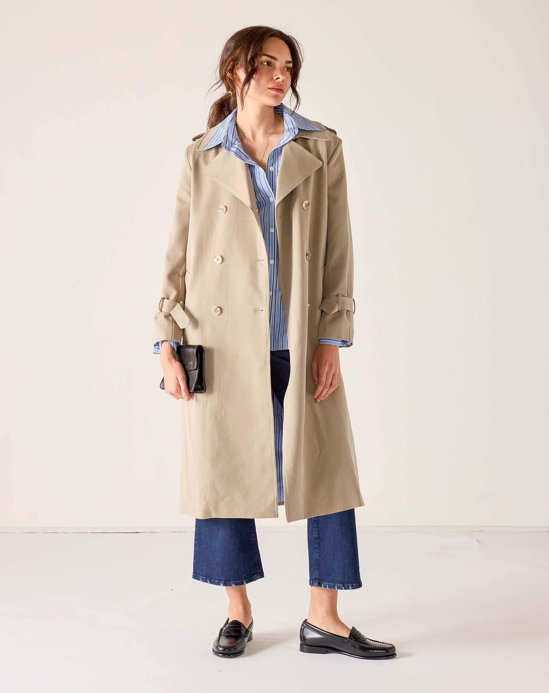 Classic khaki trench coat with a double-breasted design and buttoned cuffs.