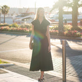 Women's travel-friendly black satin-finish midi dress with ruffled cap sleeves.