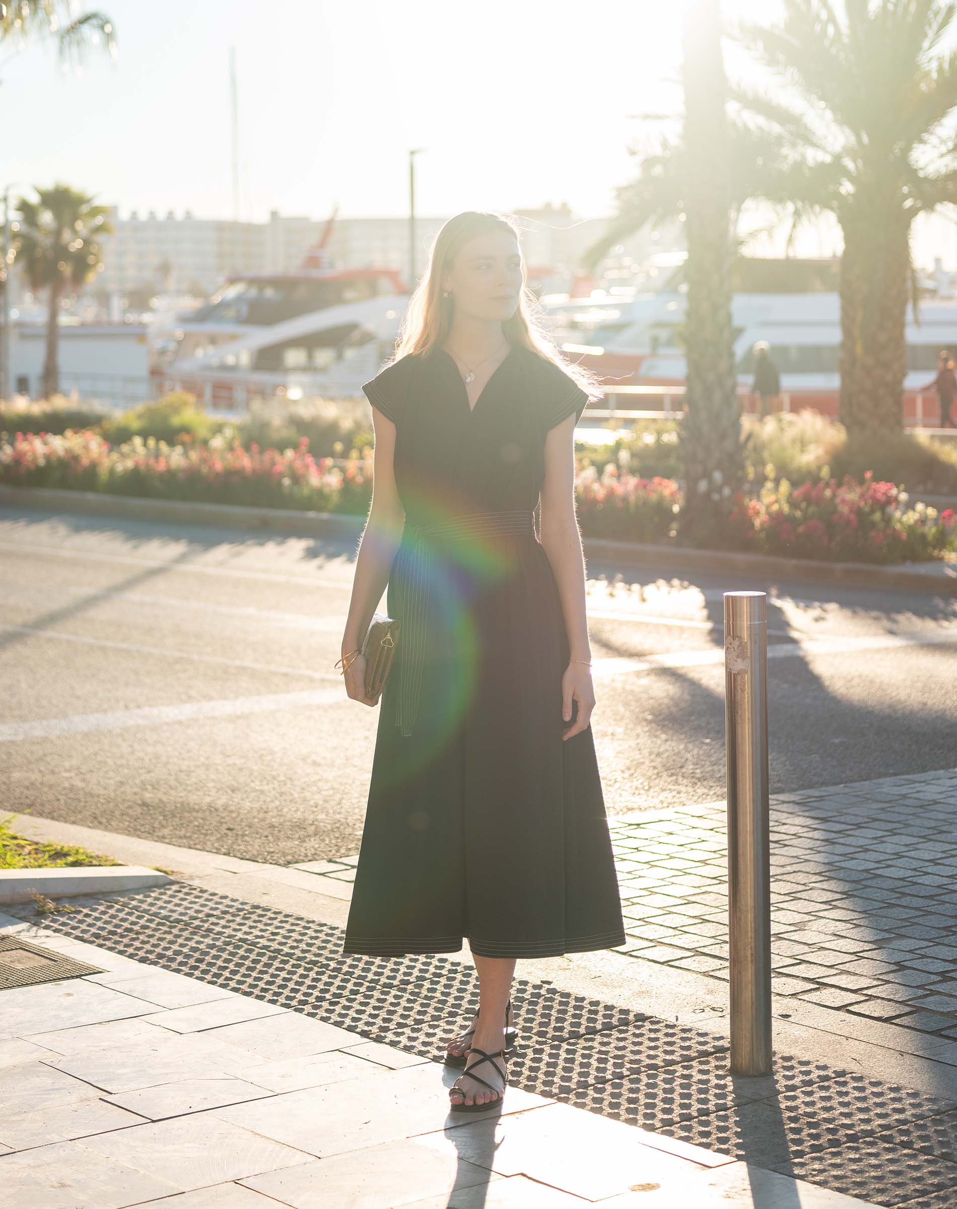Women's travel-friendly black satin-finish midi dress with ruffled cap sleeves.