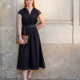 Black pleated midi dress with short sleeves and belt detail.